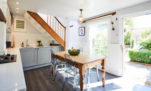 a kitchen with a wooden table and chairs at Cottage on The Croft in Hungerford