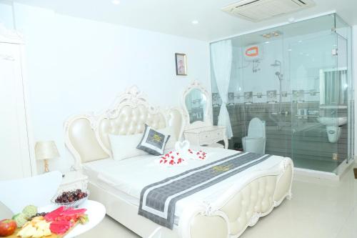 a white bedroom with a white bed and a bathroom at Noi Bai Ville Airport Hotel in Hanoi