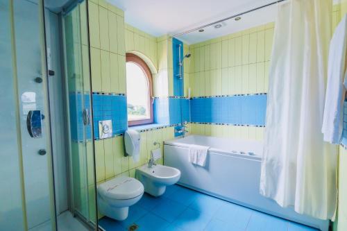 un bagno blu e giallo con servizi igienici e lavandino di Mirage Hotel a Nesebar