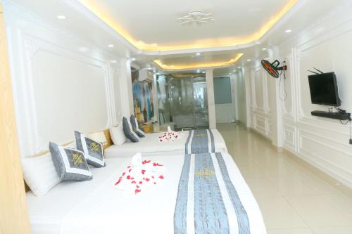 een hotelkamer met een groot bed met rode kussens bij Noi Bai Ville Airport Hotel in Hanoi