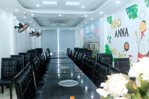 a long table in a room with black chairs at Noi Bai Ville Airport Hotel in Hanoi