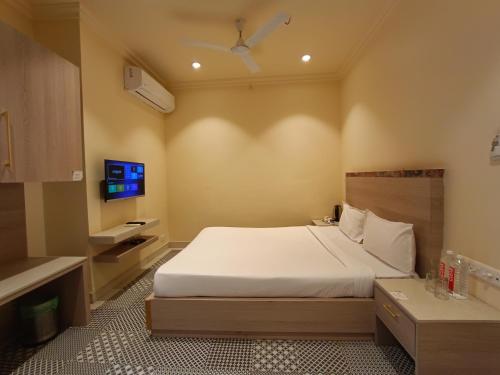 a bedroom with a large bed and a tv at Bougainvillea Banquets and Convention Centre in Nagpur