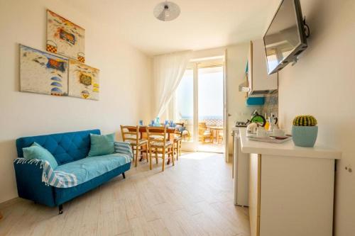 sala de estar con sofá azul y cocina en FinisTerrae Rooms and Suites, en Gagliano del Capo