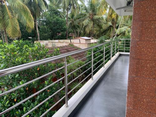 a walkway in a building with trees and plants at Panchavati Homestay in Malpe
