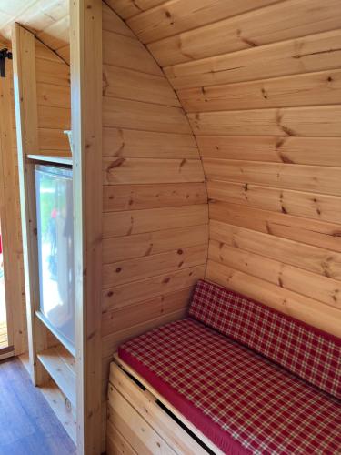 a small room with a bed in a wooden cabin at Camping u Kukačků in Horní Planá