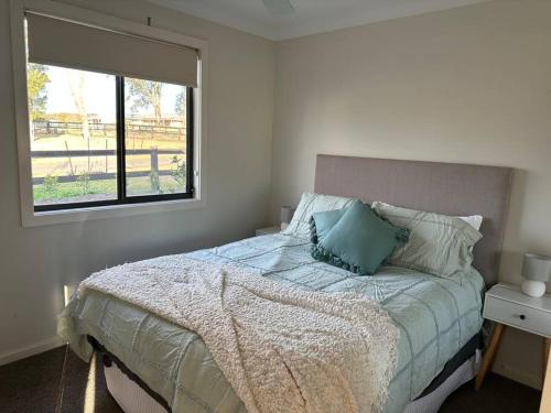 1 dormitorio con 1 cama grande y ventana en Gullivers Guest House, en East Maitland