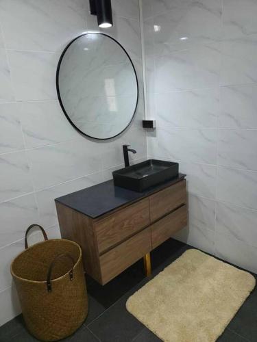 a bathroom with a sink and a mirror and a basket at Lost Paradise 1 in Hinkong