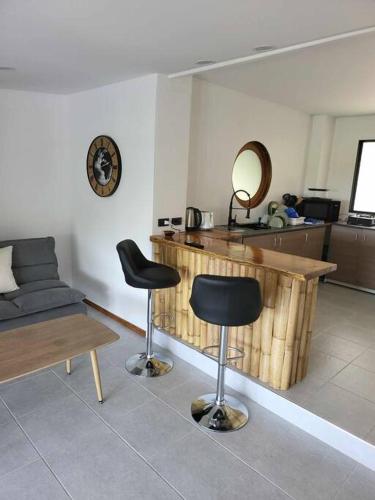 a living room with two bar stools and a table at Lost Paradise 1 in Hinkong