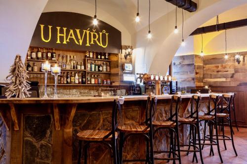 a bar with wooden stools at a bar with a counter at PENZION HRNČÍŘ in Kutná Hora