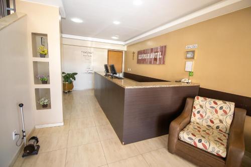 a lobby with a reception desk and a chair at Alvimar Hotel in Sobradinho