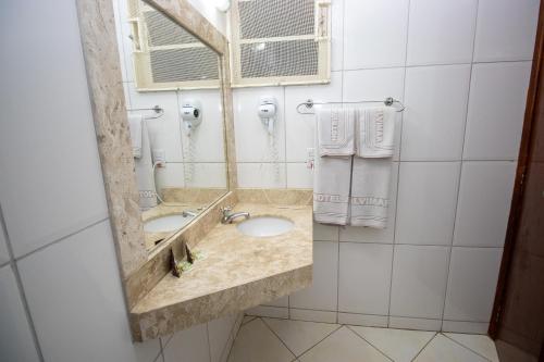 a bathroom with a sink and a mirror at Alvimar Hotel in Sobradinho