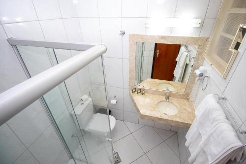 a bathroom with a sink and a toilet and a mirror at Alvimar Hotel in Sobradinho