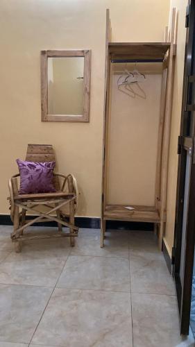 a chair with a purple pillow sitting in a room at Home Feeling Kilimanjaro in Moshi