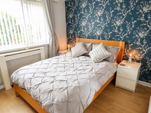 1 dormitorio con cama y pared azul en Mariai Eton Road en Mablethorpe