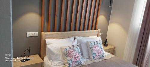 a bed with a wooden headboard and two pillows at Serenity Milatos in Milatos