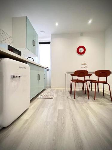 une cuisine avec une table, des chaises et un réfrigérateur dans l'établissement 【】Le Retro【】 , Belfort ville, à Belfort