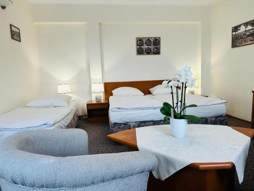 ビトゥフにあるHotel Danaのベッド2台、テーブルと椅子が備わるホテルルームです。