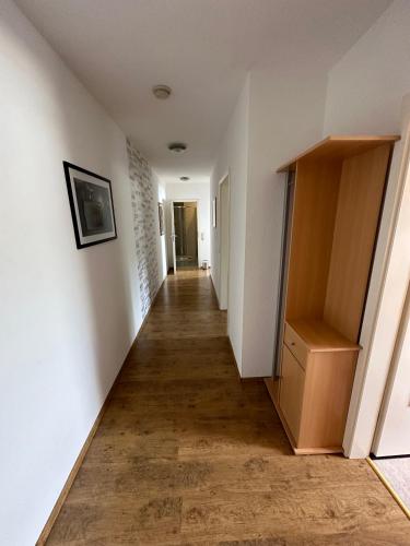 a long hallway with white walls and a wooden floor at Ferienwohnung Molly in Brunsbüttel