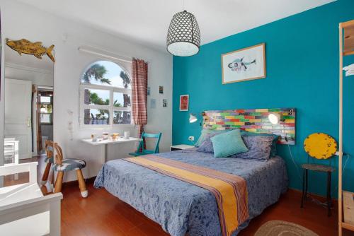 ein Schlafzimmer mit einem Bett und einer blauen Wand in der Unterkunft Loft surfer'house in Corralejo