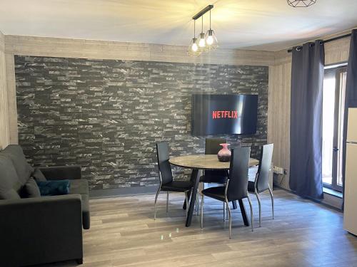 a dining room with a table and a tv on a brick wall at Vall d'Incles TOP NATURE, A13, HUT 5836 in Canillo