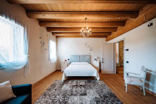 sypialnia z łóżkiem i żyrandolem w obiekcie LOCANDA CONTA w mieście Piazzola sul Brenta