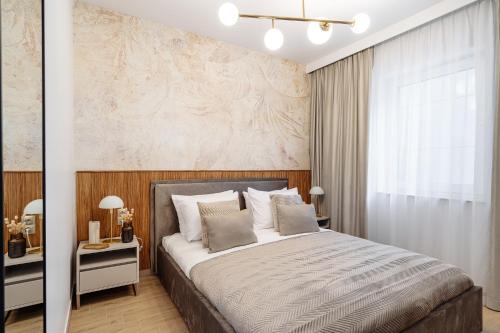 a bedroom with a large bed and a wall at Muse - LoftAffair Spa Collection in Kraków