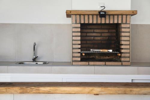チクラナ・デ・ラ・フロンテーラにあるRchico Piscina climatizadaのキッチン(レンガ造りの暖炉、シンク付)