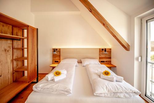 a bedroom with two beds with sunflowers on them at DASWEINBERG contactless check-in in Podersdorf am See