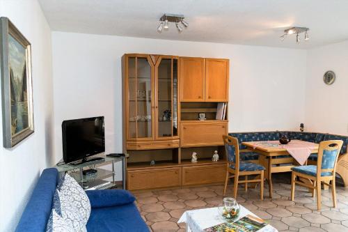 ein Wohnzimmer mit einem blauen Sofa und einem Tisch in der Unterkunft Ferienwohnung Am Berg, Eheleute Müller in Hilchenbach
