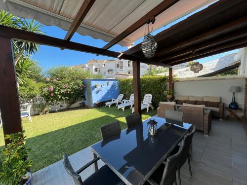 a patio with a table and chairs and a garden at Beach and Golf House La Cala de Mijas in La Cala de Mijas