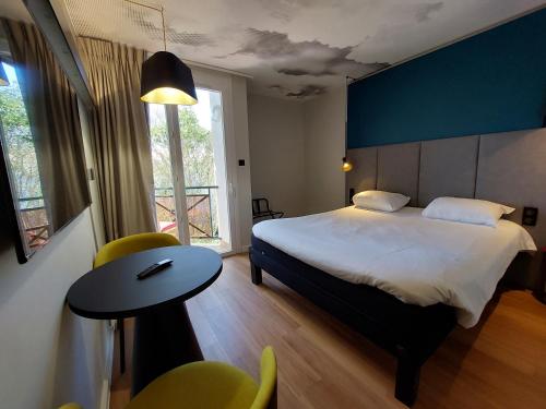 een slaapkamer met een bed, een tafel en een raam bij ibis Sète Balaruc les Bains Bien-être et Spa in Balaruc-les-Bains
