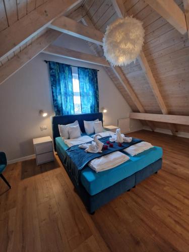 a bedroom with a blue bed in a attic at Apartamenty Polanki 2 in Łeba