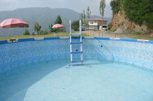 a ladder in the middle of a swimming pool at Ihram Hotel And Guest House in Swat