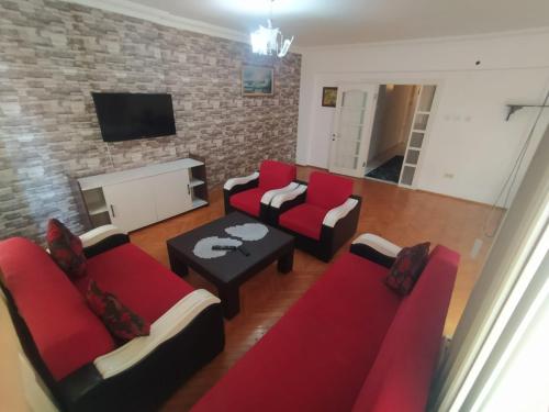 sala de estar con muebles de color rojo y pared de ladrillo en 3+1 Full eşyalı apartman dairesi, en Antalya