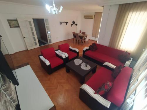 una sala de estar con sofás rojos y una mesa. en 3+1 Full eşyalı apartman dairesi, en Antalya