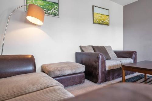 uma sala de estar com mobiliário de couro e uma mesa em Glovers Lodge - Charming 3 Bed Retreat near City Centre em Derby