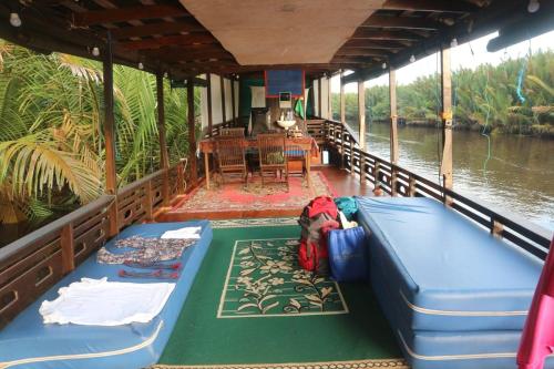 un barco en un río con 2 camas y una mesa en Orangutan Kelotok Houseboat for 6 person, en Pangkalan Bun