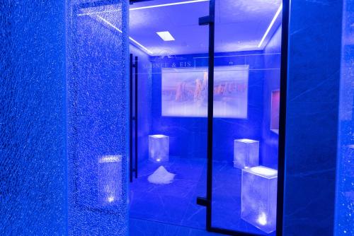 a bathroom with blue walls and a glass shower stall at Posthotel Hofherr in Königsdorf