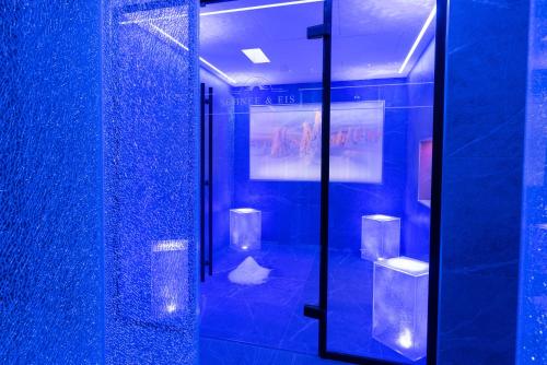 ein Badezimmer mit blauen Wänden und einer Glasduschkabine in der Unterkunft Posthotel Hofherr in Königsdorf