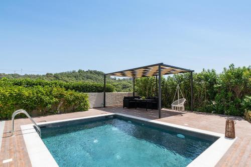 een zwembad met een pergola naast een huis bij Dioni Pool House in Ialyssos