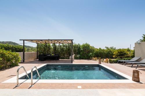 een zwembad in een achtertuin met een pergola bij Dioni Pool House in Ialyssos