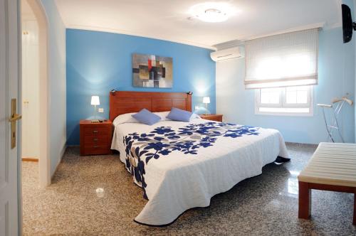 een slaapkamer met een bed met een blauwe muur bij Siesta Suites in Maspalomas