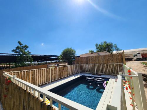 una piscina en el patio trasero con una valla de madera en וילה בגליל Vila Galilee, en Shadmot Devora
