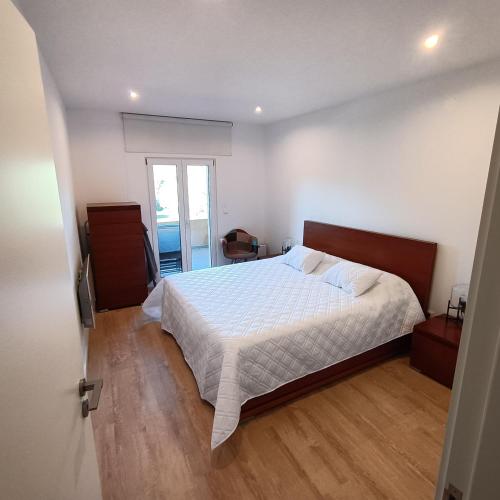 a bedroom with a large bed with a wooden floor at AQUAVIEW - VENDA NOVA in Venda Nova