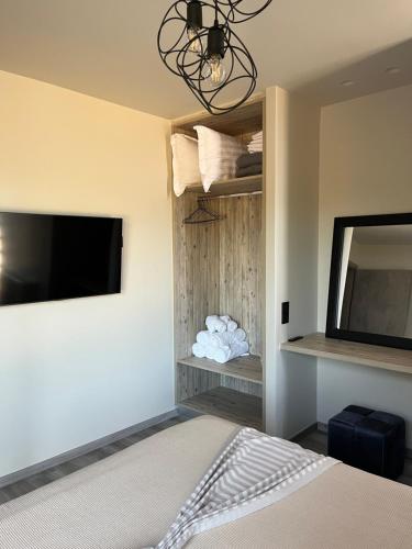 a bedroom with a bed and a flat screen tv at Grand Kourouta in Kourouta