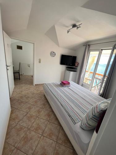 a bedroom with a bed and a large window at Apartmani Kalinic in Bijela