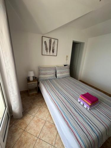 a bedroom with a bed with a pink pillow on it at Apartmani Kalinic in Bijela