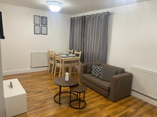 a living room with a couch and a table at T Lodge in Abbey Wood