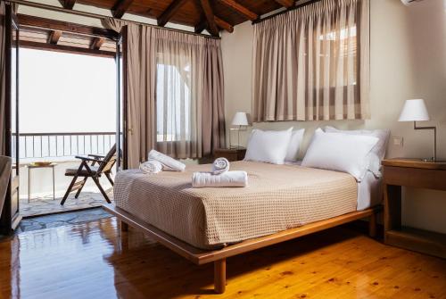 a bedroom with a bed with two towels on it at Dohos Hotel in Karítsa
