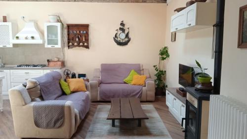 a living room with two couches and a tv at Casa di Dario in Pettenasco